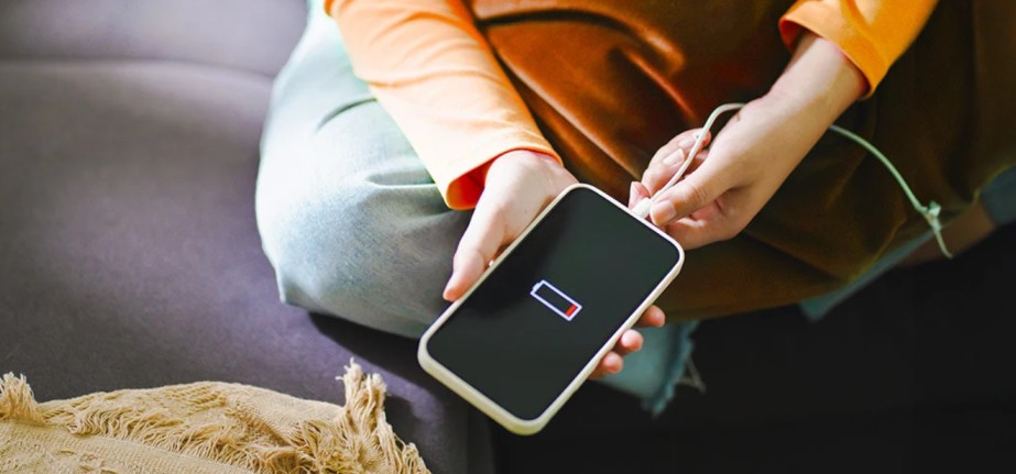 a man holding a smartphone with battery issues